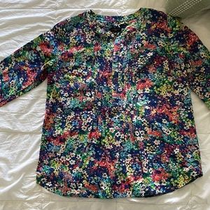 Like new 100 % cotton floral blouse with ruffles around long sleeves.